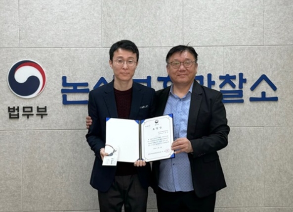 이충구 소장이 이정주 계장에게 표장장을 전달하고 기념촬영.(사진제공=논산보호관찰소)