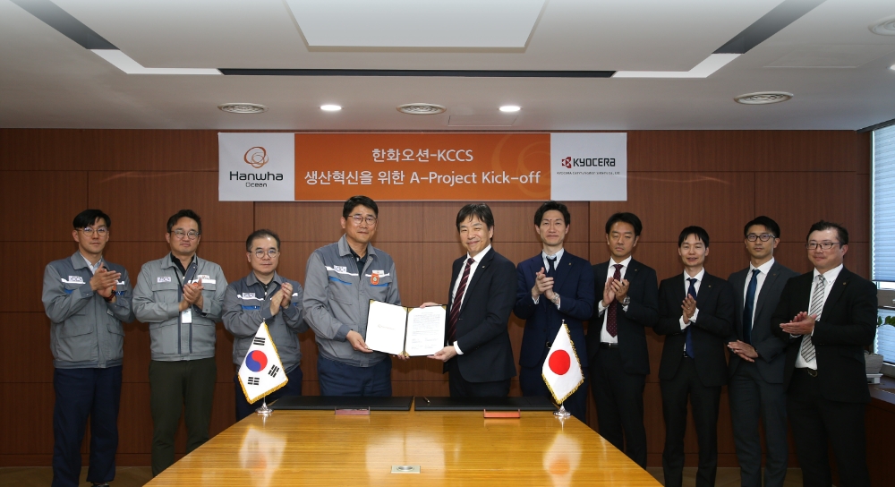 한화오션 조선소장 이길섭 부사장(왼쪽에서 네번째)이 교세라社의 마츠나가 카즈히로 사업부장(왼쪽에서 다섯번째)과 계약서에 서명하고 기념 촬영하는 모습.(사진=한화오션)