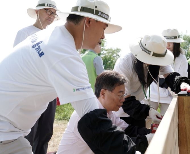 신상진 성남시장과 HD현대사이트솔루션 임직원이 습지생태원(2만7600㎡ 규모)에 있는 외래종과 고사목 제거하고, 비오톱을 조성하는 작업을 하고 있다.