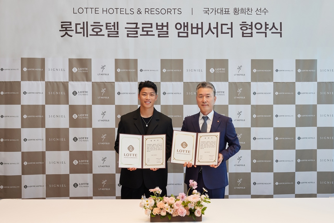 롯데호텔앤리조트 김태홍 대표이사와 황희찬 선수가 롯데호텔 글로벌 앰버서더 협약식에서 포즈를 취하고 있다.(사진=롯데호텔앤리조트)