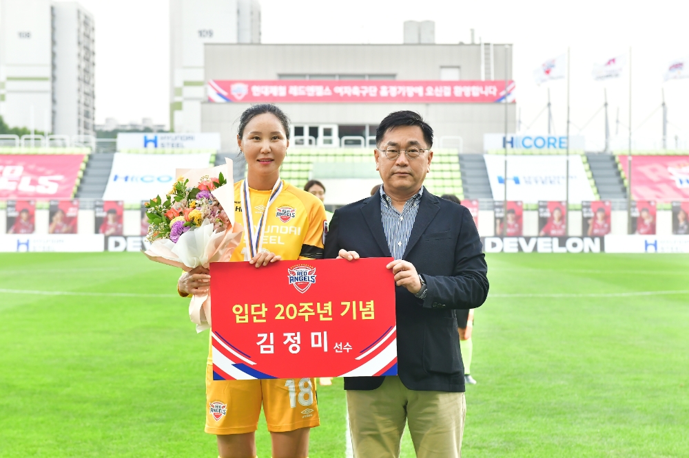 서상원 현대제철 레드엔젤스 단장이 꽃다발을 전달하고, 김정미 선수와 기념 촬영을 하고 있다.(사진=현대제철)