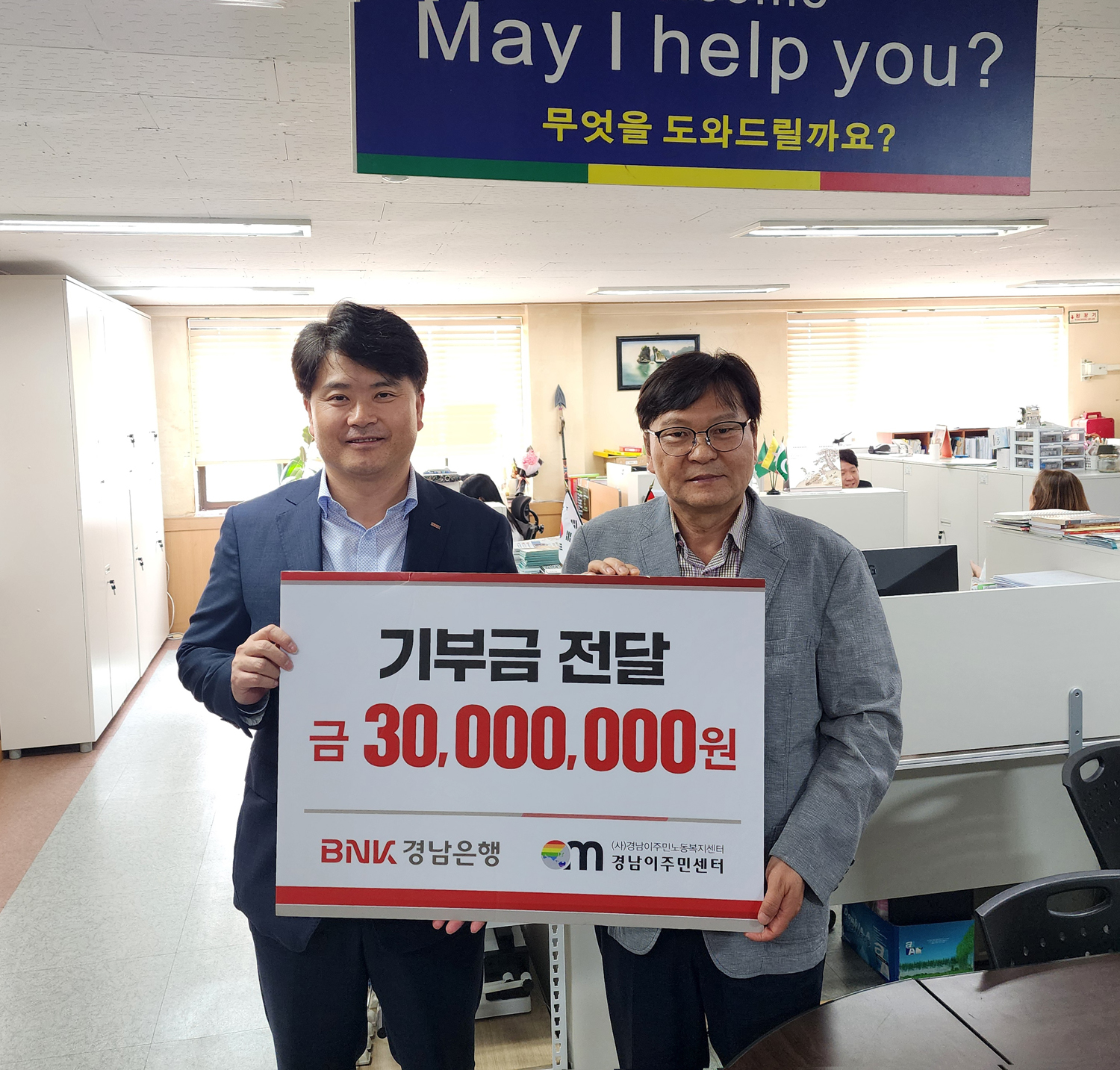 BNK경남은행 홍응일 상무(사진 왼쪽)가 (사)경남이주민노동복지센터 이철승 대표에게 ‘기부금 3000만원 기탁 증서’를 전달하고 있다. 사진=BNK경남은행