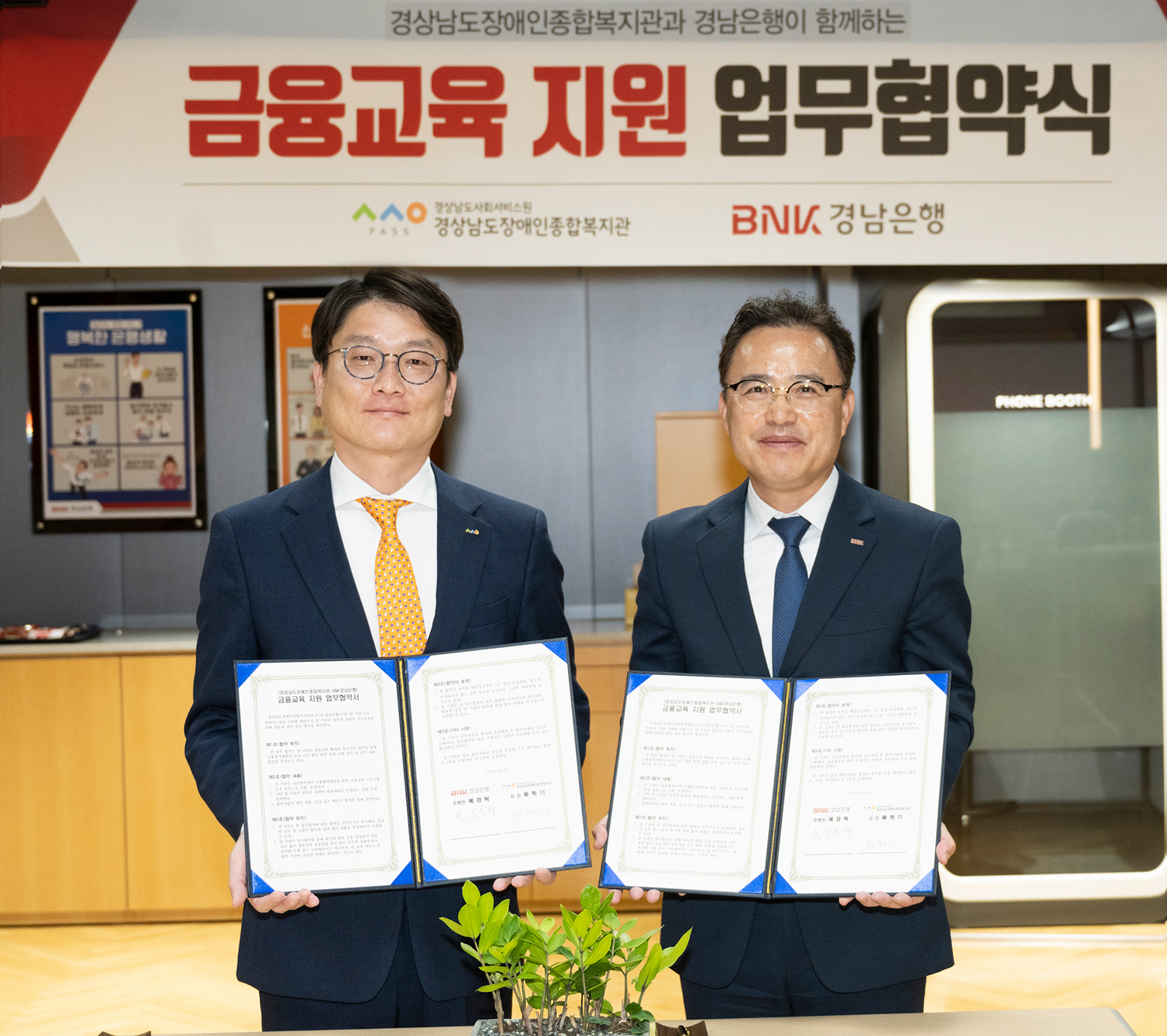 BNK경남은행 박두희 상무(사진 오른쪽)와 경상남도장애인종합복지관 류학기 관장이 ‘금융교육 지원 업무 협약’을 체결하고 있다. 사진=BNK경남은행