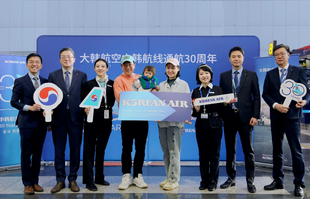 지난 22일 베이징 서우두 국제공항에서 KE2202편 30번째 탑승수속 승객인 리우 지아시(LIU JIAXI)씨(오른쪽에서 네 번째)가 한국행 왕복 비즈니스 항공권 1매를 전달받고 대한항공 관계자들과 기념사진을 촬영하고 있다.(사진=대한항공)