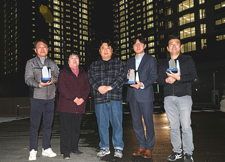 김국지 입주예정자협의회장(가운데)을 비롯한 입주예정자들과 감사패를 들고 기념촬영을 하고 있다.(사진=SM그룹)