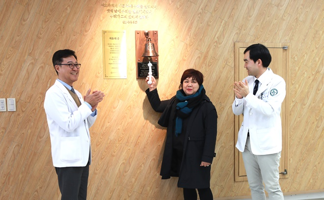 왼쪽부터 최종순 병원장, 치유의종을 타종하는 양지원 씨, 주치의 최진혁 교수가 축하의 박수를 보내고 있다.(사진제공=고신대복음병원)