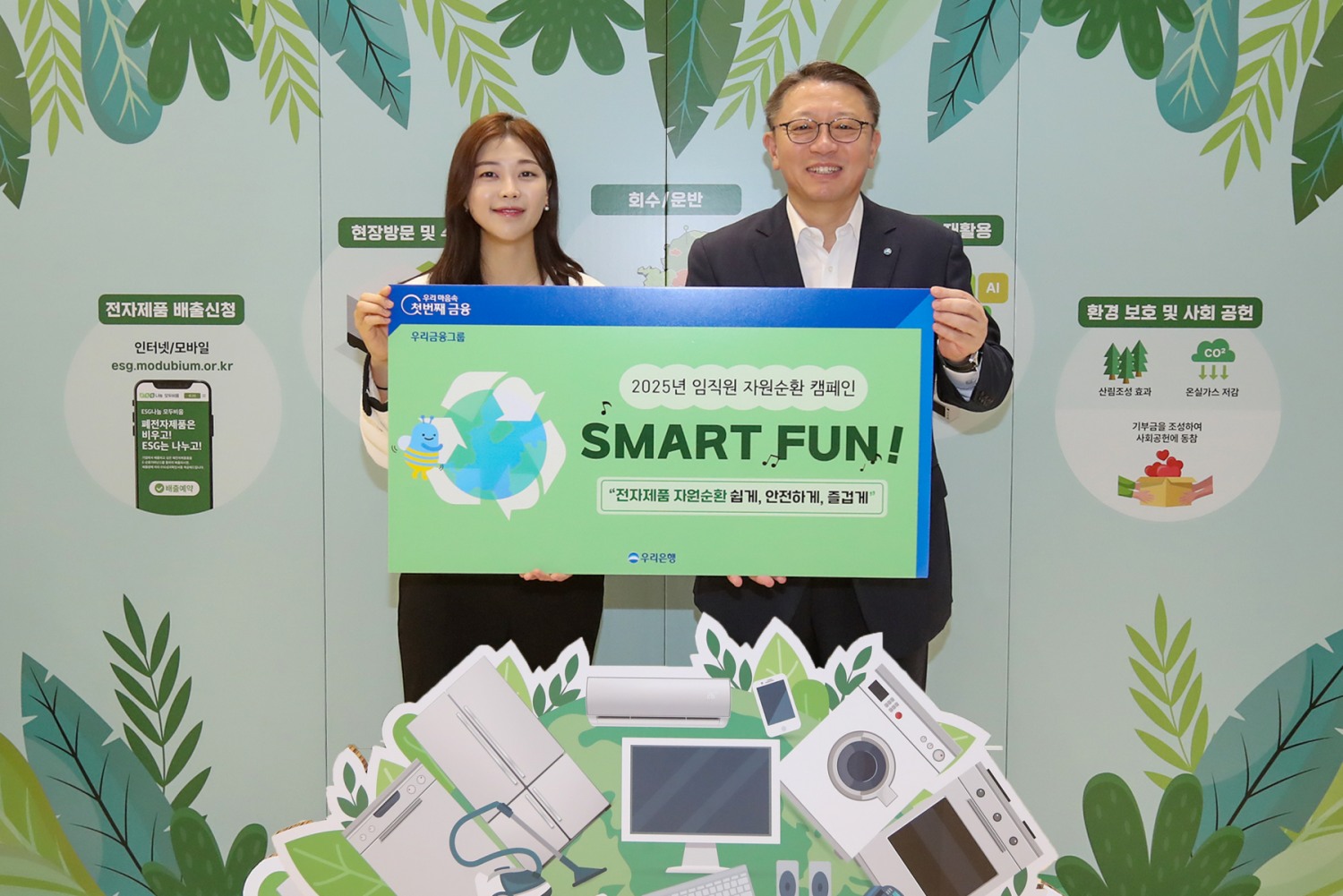 22일 우리은행 본점에서 정진완 은행장(오른쪽)이 ‘제55회 지구의 날’을 맞아 실시한 임직원 자원순환 캠페인 ‘Smart Fun(전자기기 자원순환 쉽게, 안전하게, 즐겁게!)’에 참석해 기념촬영을 하고 있다. 사진=우리은행