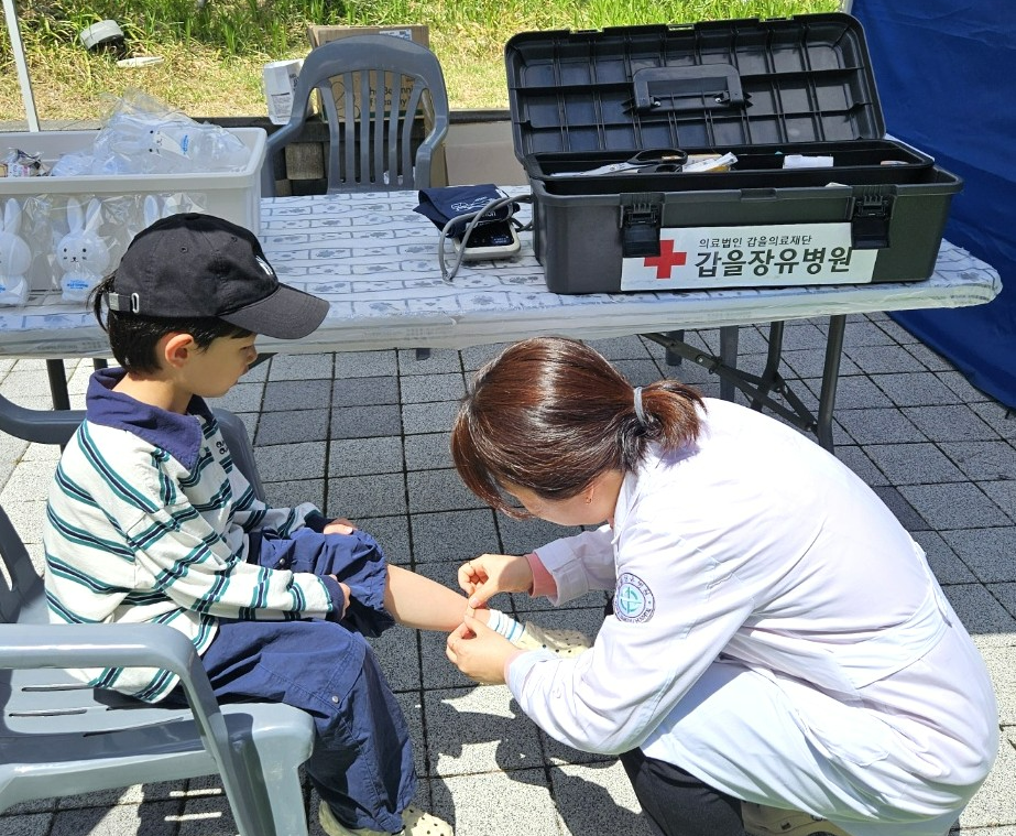 갑을장유병원 의료진이 지난달 19일 장유스포츠센터 운동장 및 실내체육관에서 열린 제25회 ‘장유의 날 행사’에 참가한 관람객을 치료하고 있다.(사진=KBI그룹)