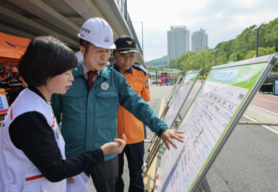 전성수 서초구청장(가운데)이 21일 서초구 양재천·여의천 합수부에서 실시한 2025년 재난대응 안전한국훈련에서 관계자들과 상황을 점검하고 있다.