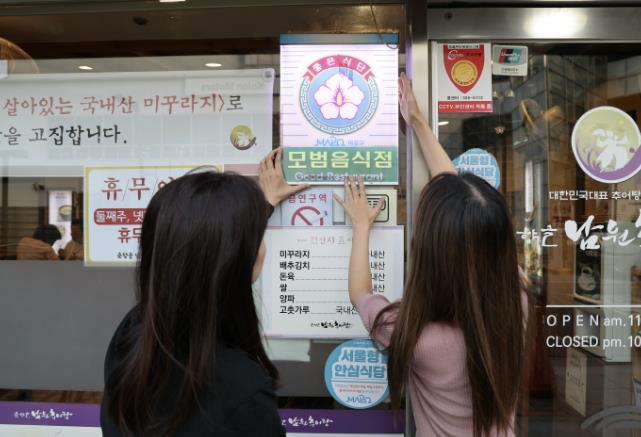 모범음식점으로 선정된 음식점에 모범음식점 표지판을 다는 모습