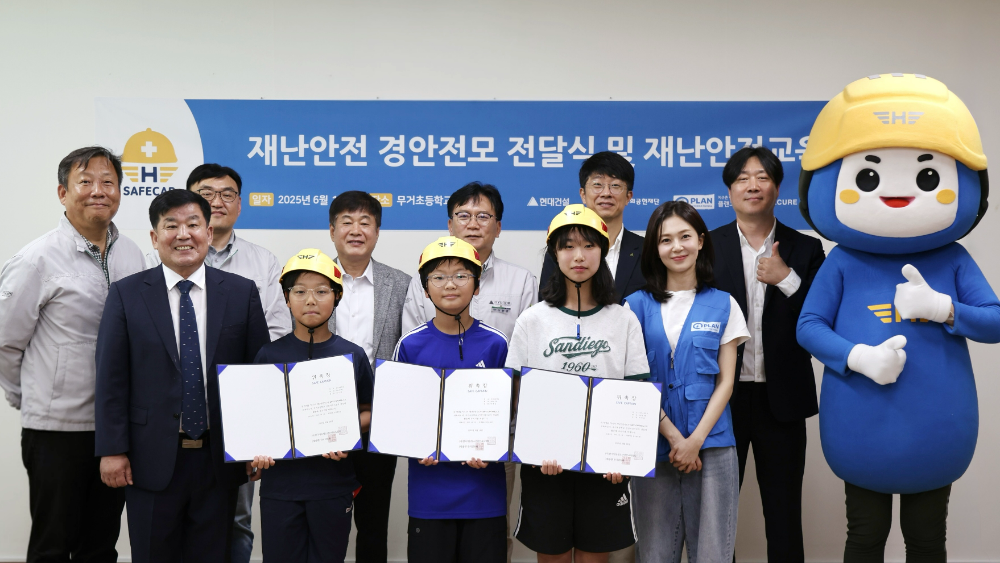 뒷줄 왼쪽에서 3번째부터)건설산업사회공헌재단 이재식 사무처장, 현대건설 이현영 실장, 현대건설 김진홍 실장, 플랜코리아 이재명 실장과 (앞줄 왼쪽)무거초등학교 정우규 교장이 <재난안전교육 및 어린이용 경안전모 전달식> 행사 사진을 촬영하고 있다.(사진=현대건설)