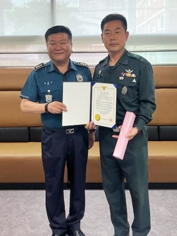 70대 남성의 귀중한 생명을 구한 일로 부산기장경찰서장으로부터 감사장을 받고 기념 촬영 하고 있는 유주흥 기장군 기동대장(사진우측).(사진제공=육군 53사단)