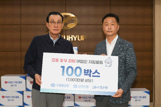 노동진 수협중앙회장(왼쪽)이 24일 송민수 당진수협 조합장에게 1천만 원 상당의 집중 호우 피해 어업인 지원 물품을 전달하고 있다.(사진= 수협중앙회)