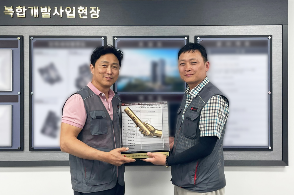 롯데건설 주택안전팀 이승환 상무(왼쪽)가 현장소장에게 ‘안전 바통’을 전달하고 있다.(사진=롯데건설)