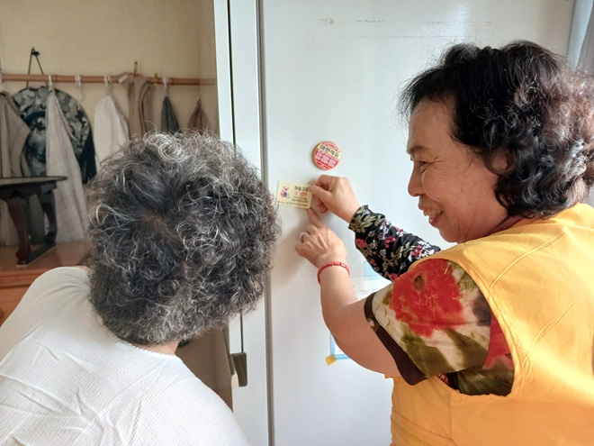 대한적십자사부산지사봉사원이 지난 8월 14일 수혜자 노인가구에 자살예방 상담번호를 안내하고 있다.(제공=대한적십자사부산지사)