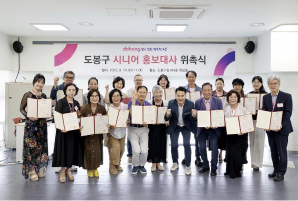 도봉구 시니어 홍보대사들이 위촉장을 들고 단체 사진을 찍고 있다