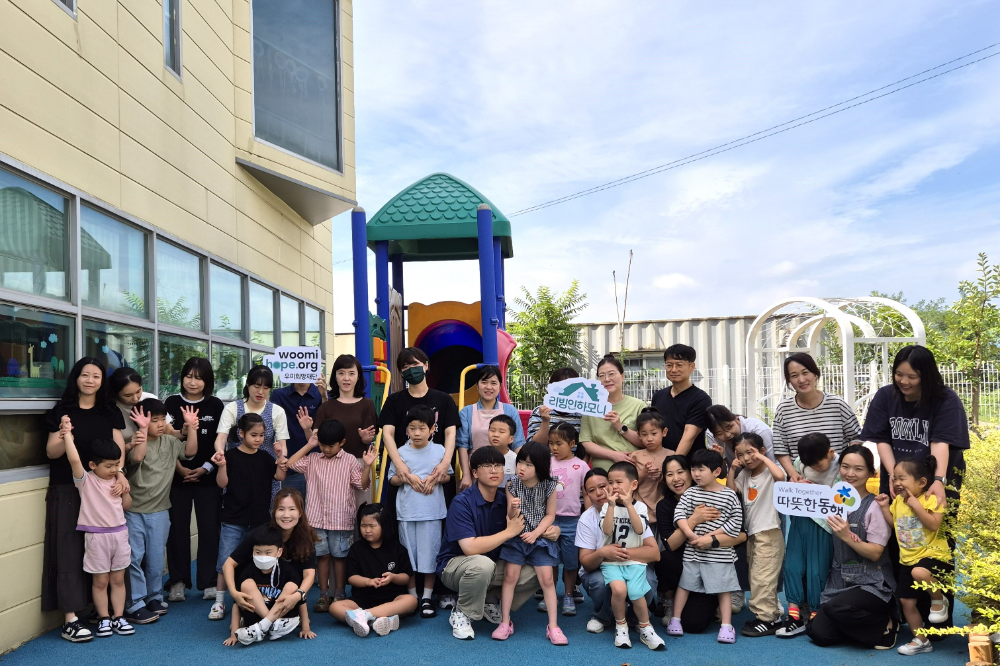 구미 하늘어린이집 원아와 교사가 ‘2025 리빙인하모니’를 통해 개선된 외부놀이공간에 모여 있다.(사진=우미희망재단)