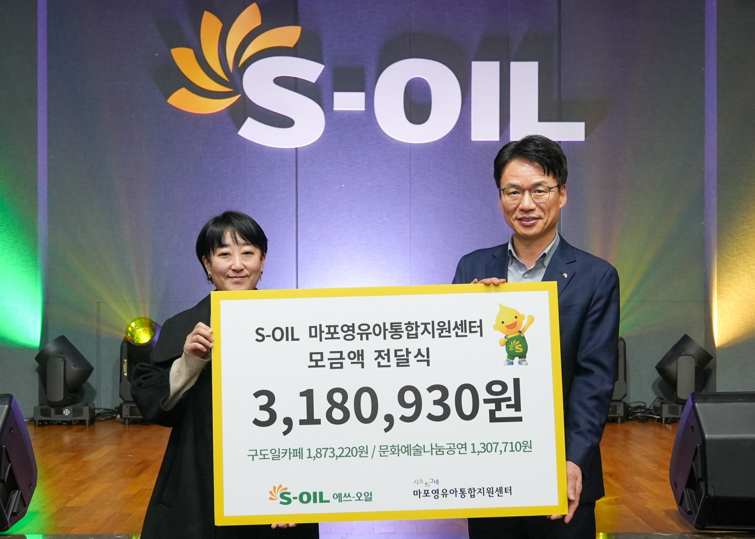 S-OIL 서경섭 부문장(오른쪽)이 마포영유아통합지원센터 ‘시소와그네’ 임명연 관장(왼쪽)에게 모금액을 전달하고 기념 촬영을 하고 있다.(사진=에쓰오일)