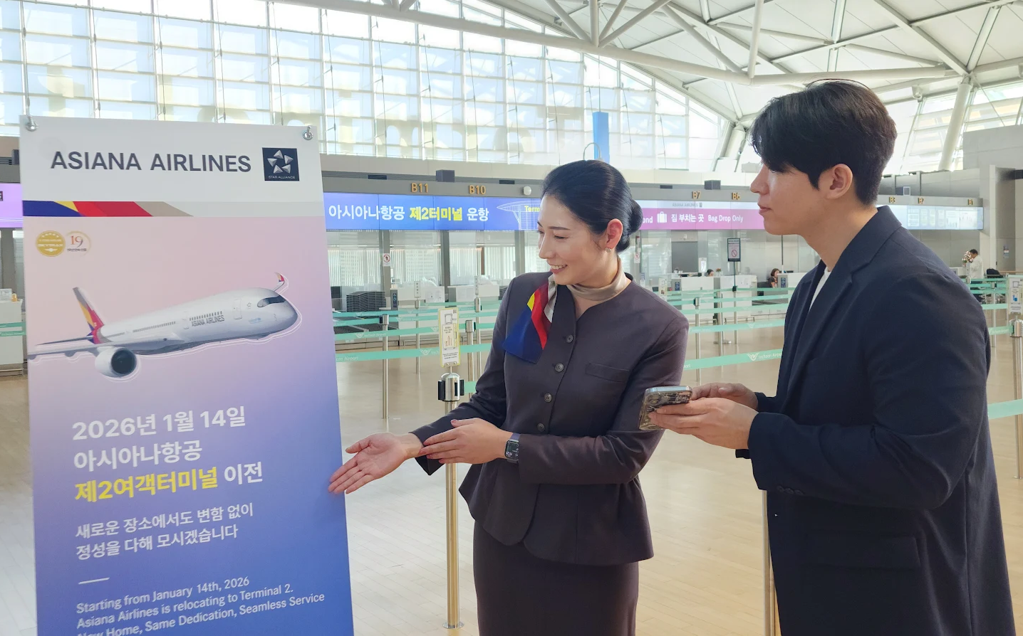 아시아나항공이 이달 14일부터 인천공항 제2여객터미널에서 운항한다. 아시아나항공 직원이 승객에게 터미널 이전 안내를 하고 있다.(사진=아시아나항공)