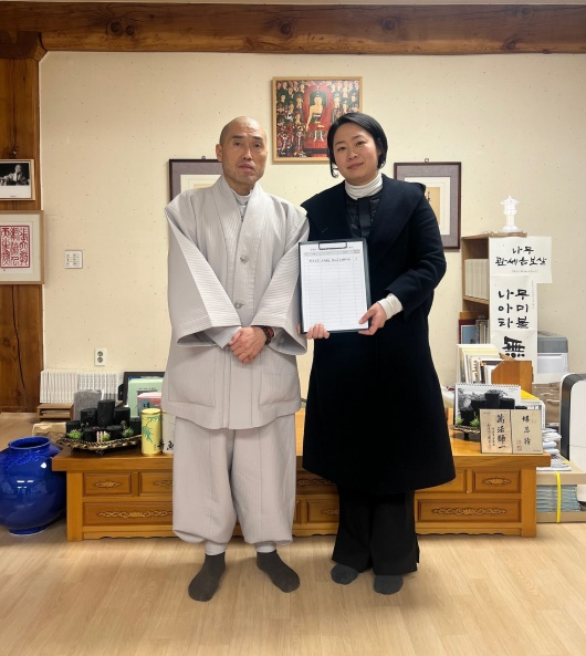 문나영 의원이 범어사 정오 주지스님을 예방해 본사무소 금정구 유치에 대해 설명하고 서명을 받은 뒤 서명지를 내보이며 기념촬영.(사진제공=문나영 의원)