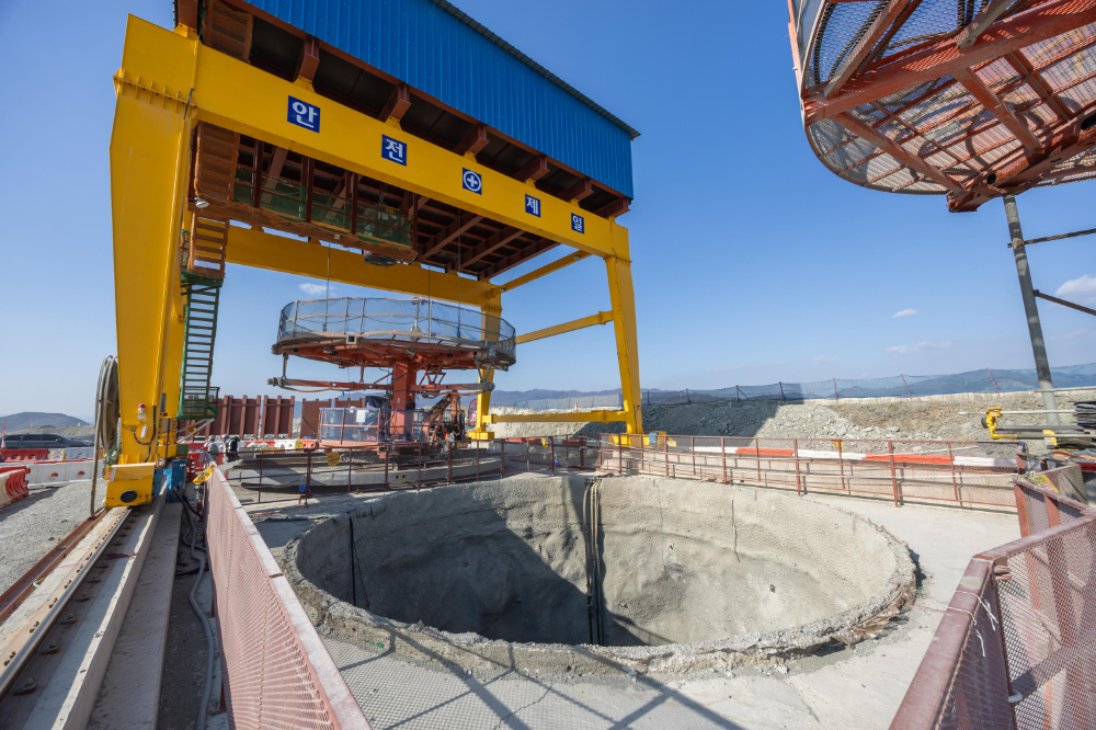 부산항 신항 북측 컨테이너부두 2단계 항만배후단지 조성 공사 현장의 갠트리 크레인 아래에 굴착이 완료된 수직터널 있다.(사진=DL이앤씨)