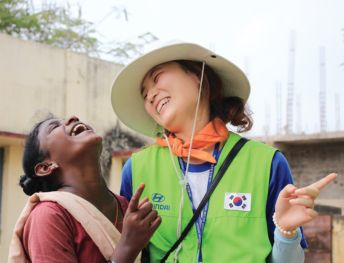 해피무브 봉사단에 참여한 자원봉사자가 현지 여성과 대화를 나누며 환하게 웃고 있다.(사진=현대차그룹)