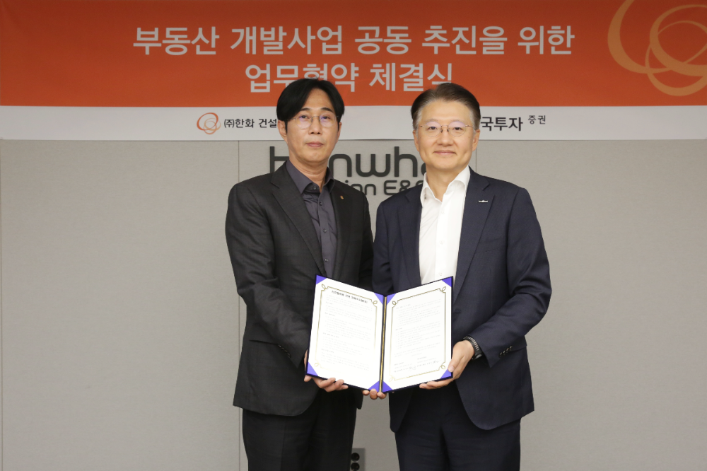 한화 건설부문 윤성호 개발사업본부장(좌측)과 한국투자증권 방창진 PF그룹장(우측)이 ‘부동산 개발사업 공동 추진을 위한 업무협약’을 체결하고 기념촬영을 하고 있다.(사진=한화 건설부문)