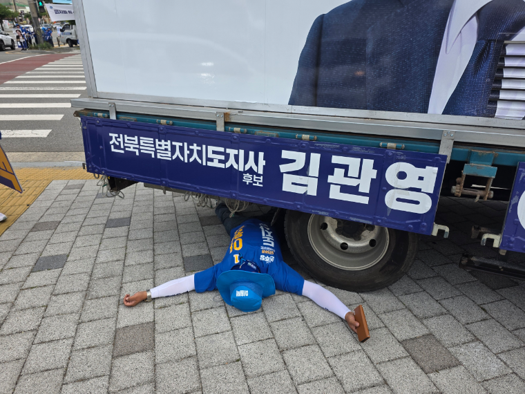차량 아래 누워있는 선거운동원 (사진=김관영 후보측)