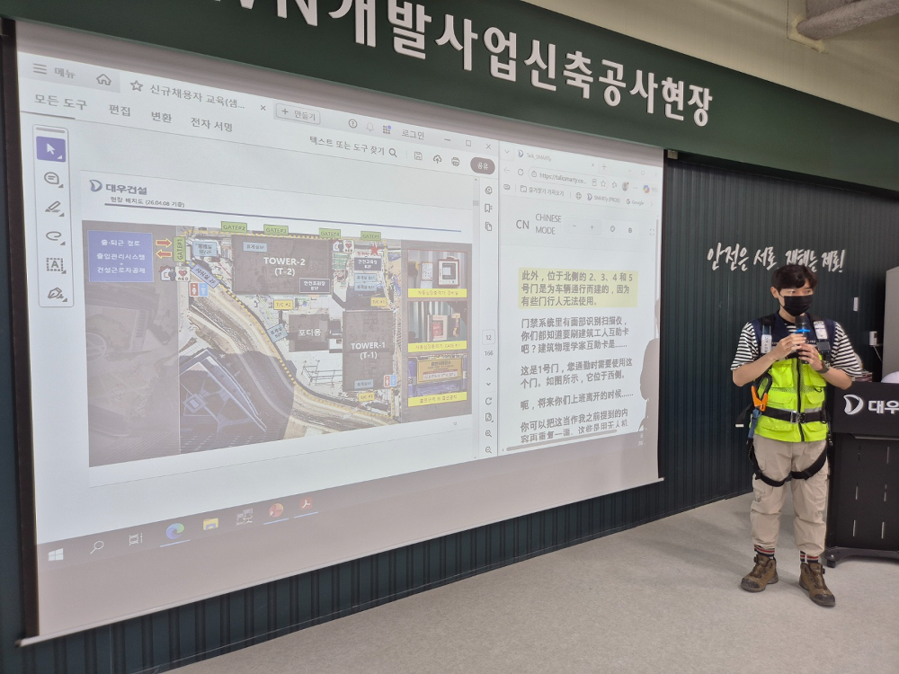 대우건설 관계자가 과천 G-TOWN 개발사업 신축공사 현장에서 외국인 근로자를 위한 AI 번역기 기능에 대해 교육 중이다.(사진=대우건설)