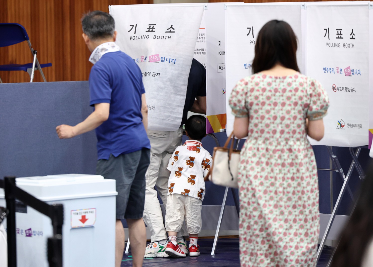 제9회 전국동시지방선거일인 3일 서울 잠전초등학교 체육관에 마련된 잠실본동 제4,5,6투표소에서 한 어린이가 투표하는 아빠를 보고 있다. 사진=연합뉴스