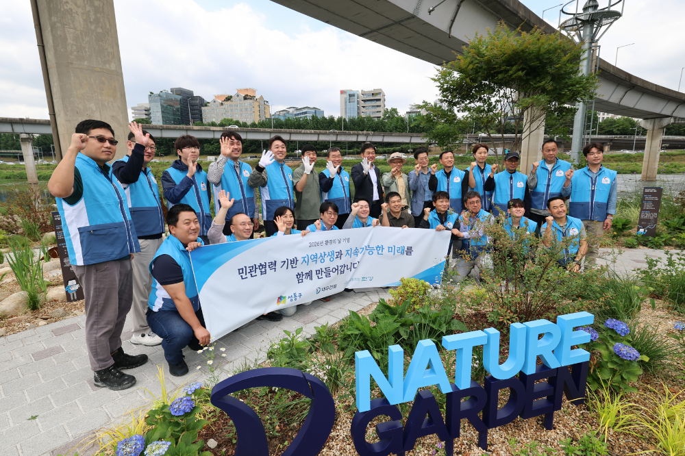 봉사활동 참석자들이 '대우건설 Nature' 앞에서 기념촬영을 하고 있다.(사진=대우건설)