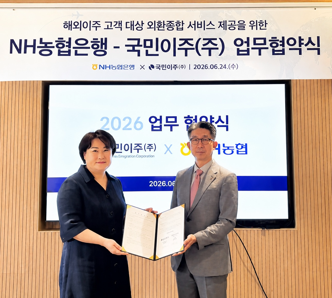 NH농협은행 외환사업부 양승식 부장(오른쪽)과 국민이주 김지영 대표이사(왼쪽)가 기념사진 촬영을 하고 있다. 사진=NH농협은행