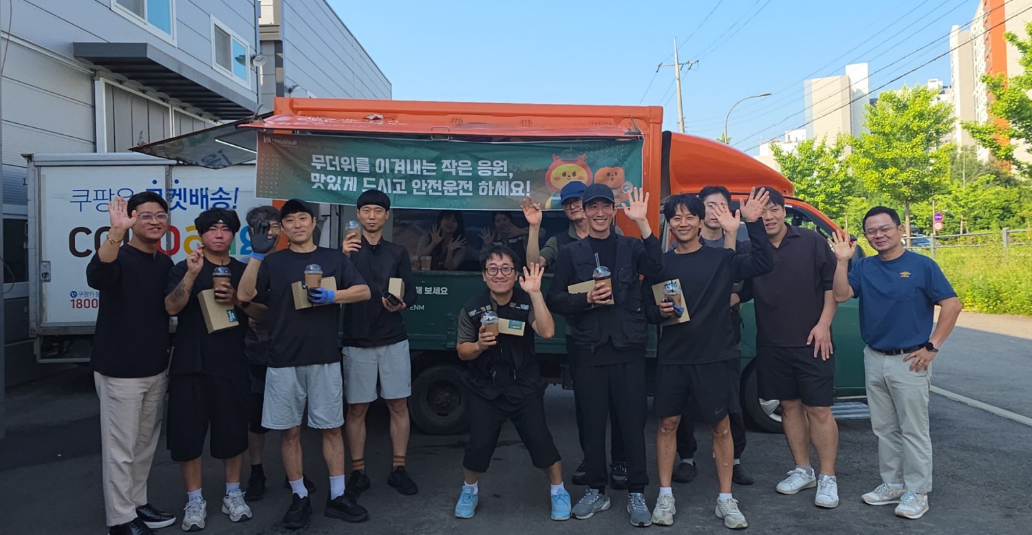 15일 HR그룹 드림카 커피차가 남양주1 별내 모바일 캠프를 방문한 가운데, HR그룹 소속 배송기사들과 임직원들이 아이스 음료와 간식 박스를 들고 현장 격려 지원 기념촬영을 하고 있다./사진=HR그룹 제공