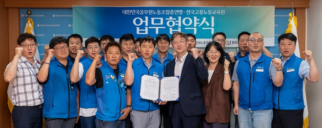 공주석 공노총 위원장(좌측)과 이종선한국고용노동교육원 원장이서명한 협약서를 내보이며 참석자들과 파이팅을 하며 기념 촬영하고 있다.(사진제공=공노총)