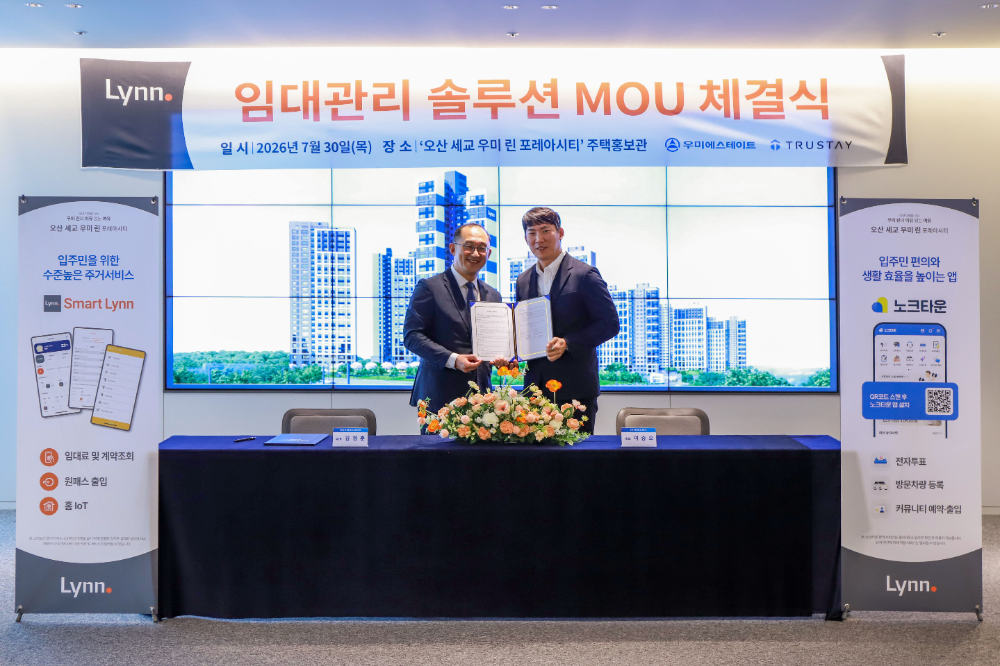 우미에스테이트 김정훈 대표와 트러스테이 이승오 대표가 30일 경기도 화성시 ‘오산 세교 우미린 포레아시티’ 주택홍보관에서 MOU를 체결하고 기념사진을 찍었다.(사진=우미건설)