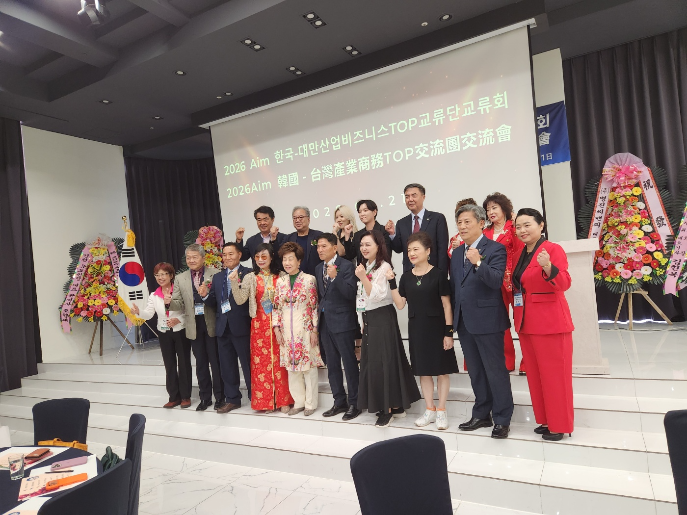 '2026 Aim 한국-대만 산업 비즈니스 TOP 교류단 아시아 산업 협력 교류회에 참석한 내빈들이 단체사진을 촬영하고 있다.