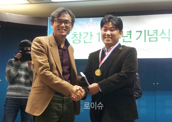 ▲오마이뉴스오연호대표로부터‘으뜸상’메달과상금을받고악수를나누는모습