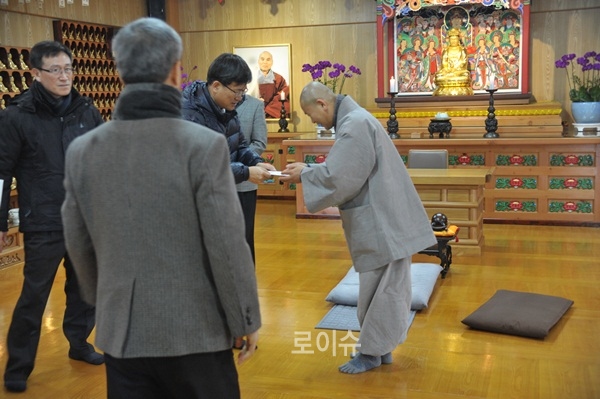 ▲법당내89위무연고순직경찰관위패에예를표하고,봉사활동을주관하는일준스님에게위문금을전달하고있다.