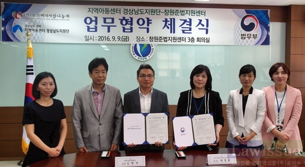 업무협약서를 내보이며 기념촬영을 하고 있다.