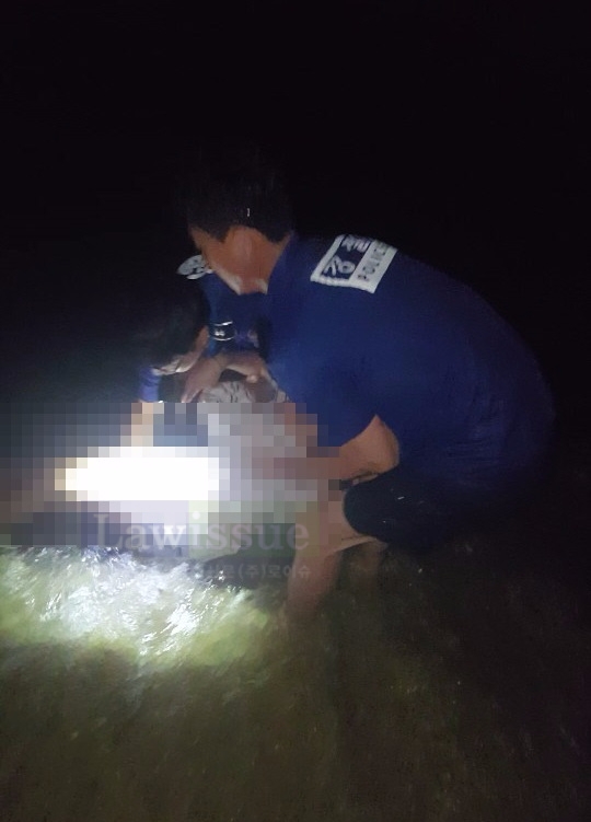 물에 빠진 여성을 구하고 있는 경찰관들.