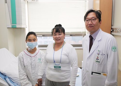 박정준 이대목동병원 흉부외과 교수(오른쪽)와 몽골에서 온 선천성 심장병 환자인 첸드마씨(왼쪽), 첸드마씨 이모(가운데)가 수술 후 병실에서 기념 촬영을 하고 있다(사진=이대목동병원)