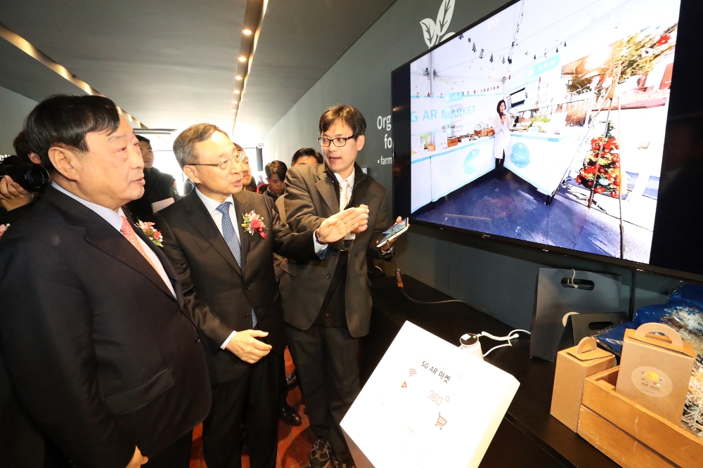 황창규 KT 회장(왼쪽)과 이희범 평창동계올림픽 위원장(오른쪽)이 의야지마을 꽃밭양지카페 2층에 마련된 5G AR 마켓 서비스에 대한 설명을 듣고 있는 모습. (사진=KT)