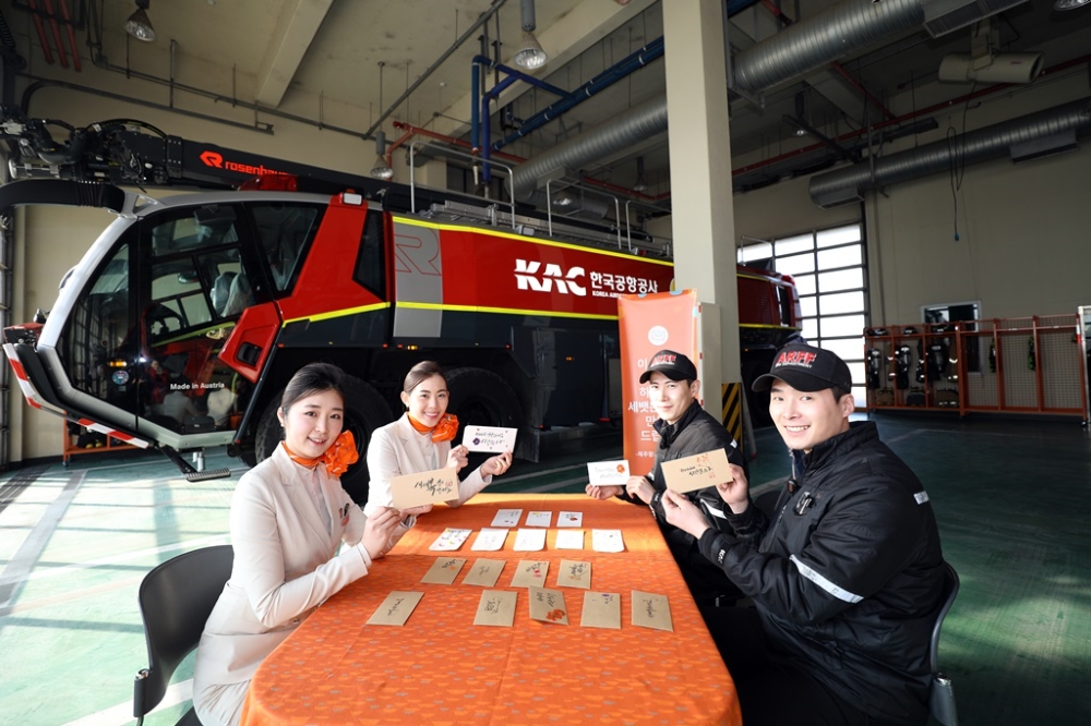 지난 6일 기내에서 캐리커처와 페이스페인팅 특화서비스를 제공하는 제주항공 ‘JJ일러스타팀’ 객실승무원들이 설을 앞두고 김포국제공항 소방구조대를 찾아 대원들에게 멋글씨(캘리그래피)로 꾸민 세뱃돈봉투를 직접 만들어주고 있다. (사진=제주항공)