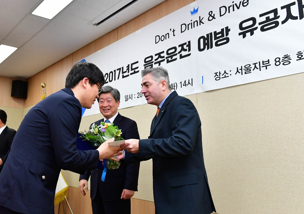 27일 도로교통공단과 함께 건전음주 캠페인의 일환으로 음주운전 예방과 단속에 남다른 공을 세운 경찰관 등을 선정해 포상했다. 오비맥주 브루노 코센티노 대표가 경찰관에게 꽃과 시상금을 수여하고 있다. (사진=오비맥주)