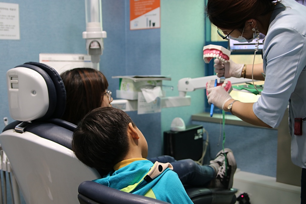 유디치과의 ‘우리동네 이 밝은 세상’ 대상자로 선정된 허 모양(12세)이 충치 치료를 받은 후, 동생인 허 모군(7세)과 함께 올바르게 칫솔질 하는 방법을 배우고 있다. (사진=유디치과)