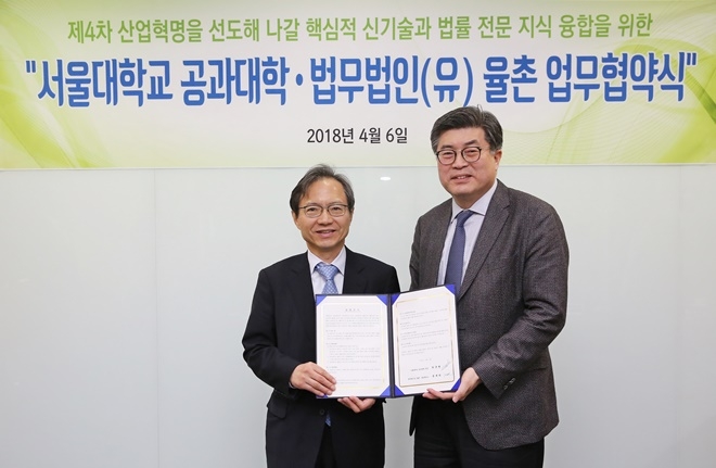 업무협약서를 내보이며 기념촬영을 하고 있다.(사진제공=율촌)