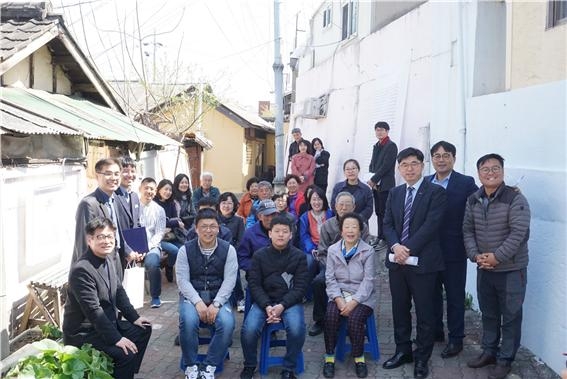 HUG STREET 1호 사업 완료를 축하하는 ‘시와 그림이 있는 골목 개장잔치’ 개최 후 관계자(스파크 민영서 대표, HUG 사회적가치실현팀 김세명 팀장, 대전문화유산 울림 안여종 대표, 소제창작촌 유혜경 대표 등) 및 주민들이 함께 기념촬영을 하는 모습.(사진=HUG)