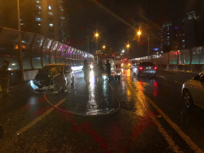 모닝차량 엔진룸 화재를 진압하고 있다.(사진제공=부산지방경찰청)