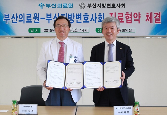 업무협약서를 내보이며 기념촬영을 하고 있다.(사진제공=부산지방변호사회)