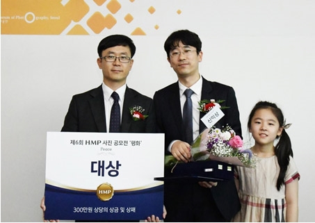 대상 수상자인 신익상 부원장(중앙)과 작품에 등장했던 자녀가 한미약품 박문화 상무와 기념촬영을 하고 있다. (사진=한미약품)